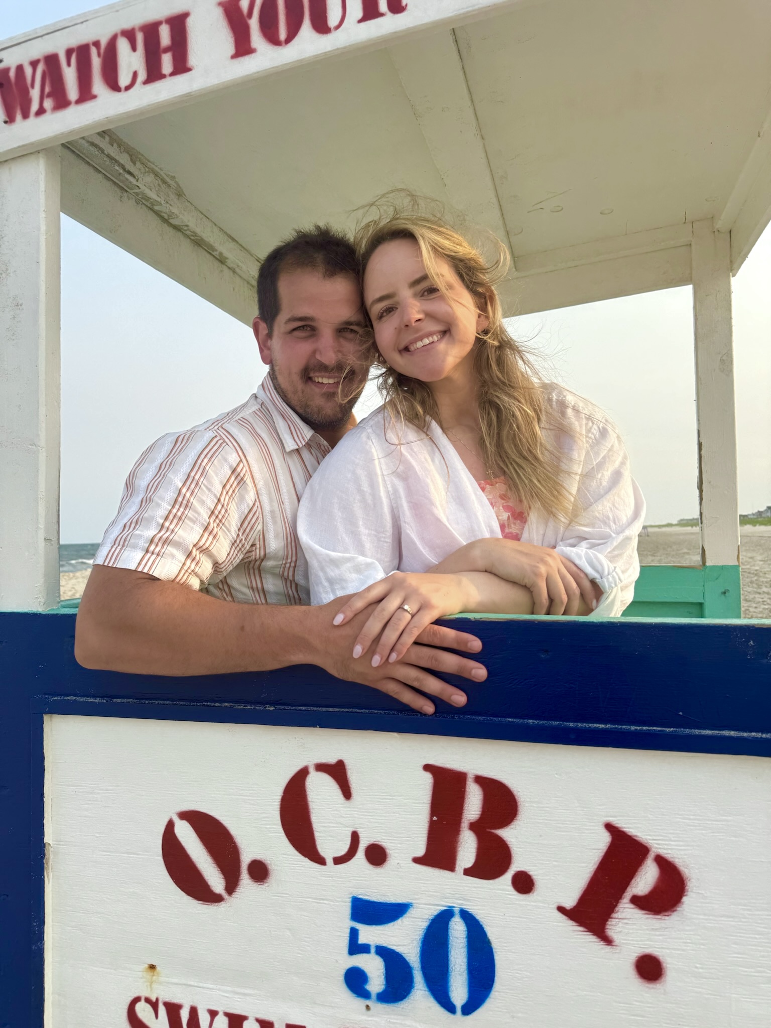 Peter and Mary smiling at a lifeguard stand in Ocean City, NJ